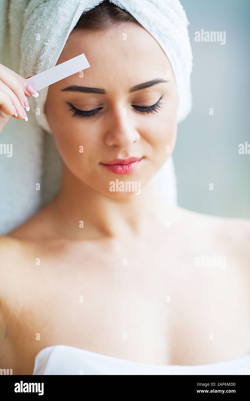 Beautician waxing young woman's eyebrows in spa center Stock Photo Alamy