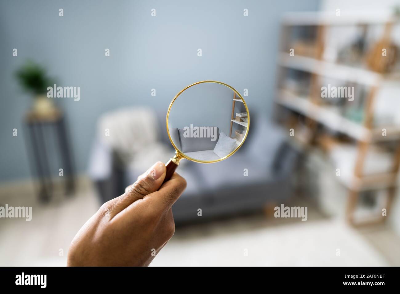 Close-up Of A Man's Hand Searching With Magnifying Glass At Home Stock Photo