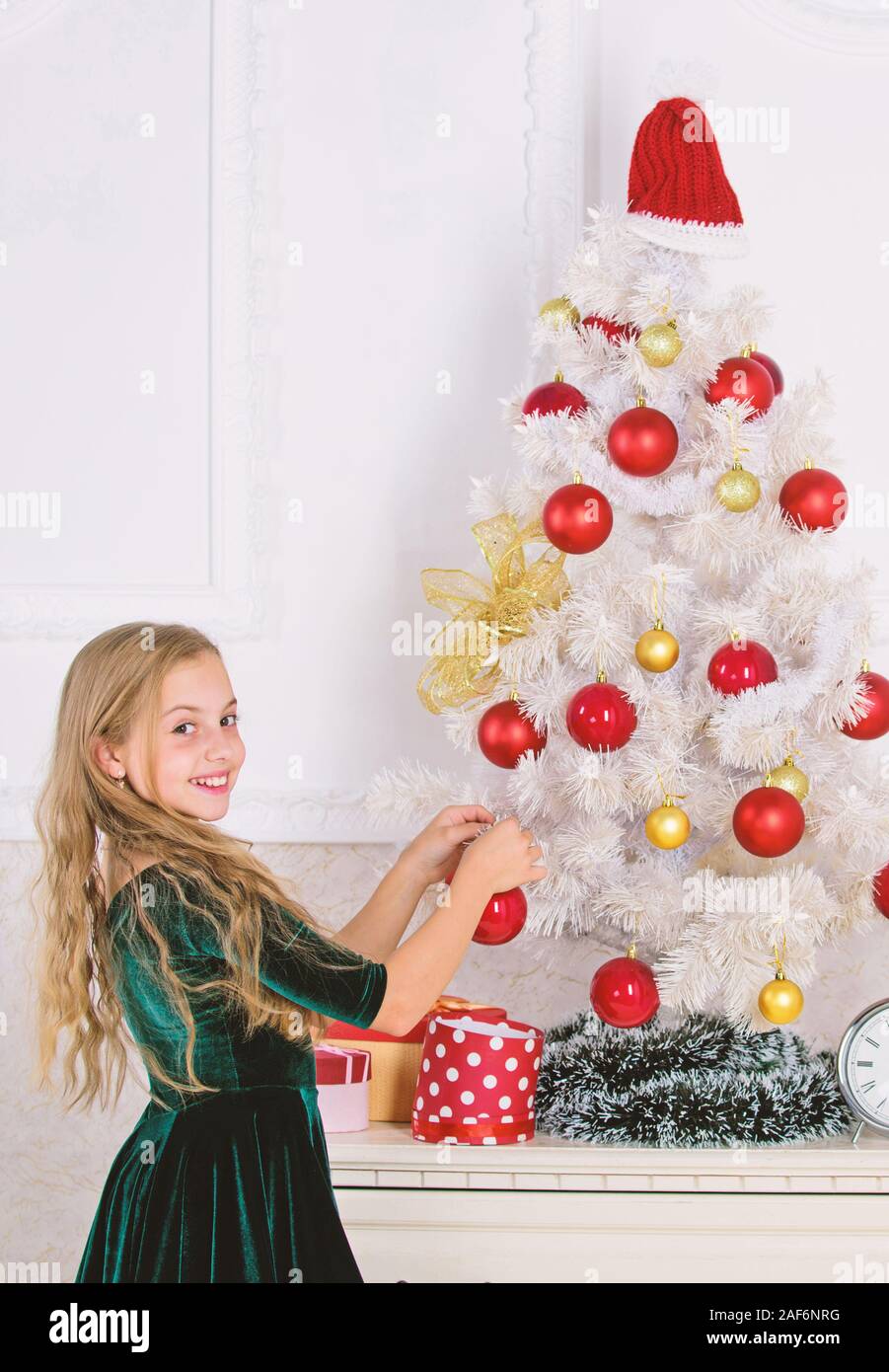 Child Put Christmas Ornament Ball On Artificial White Tree