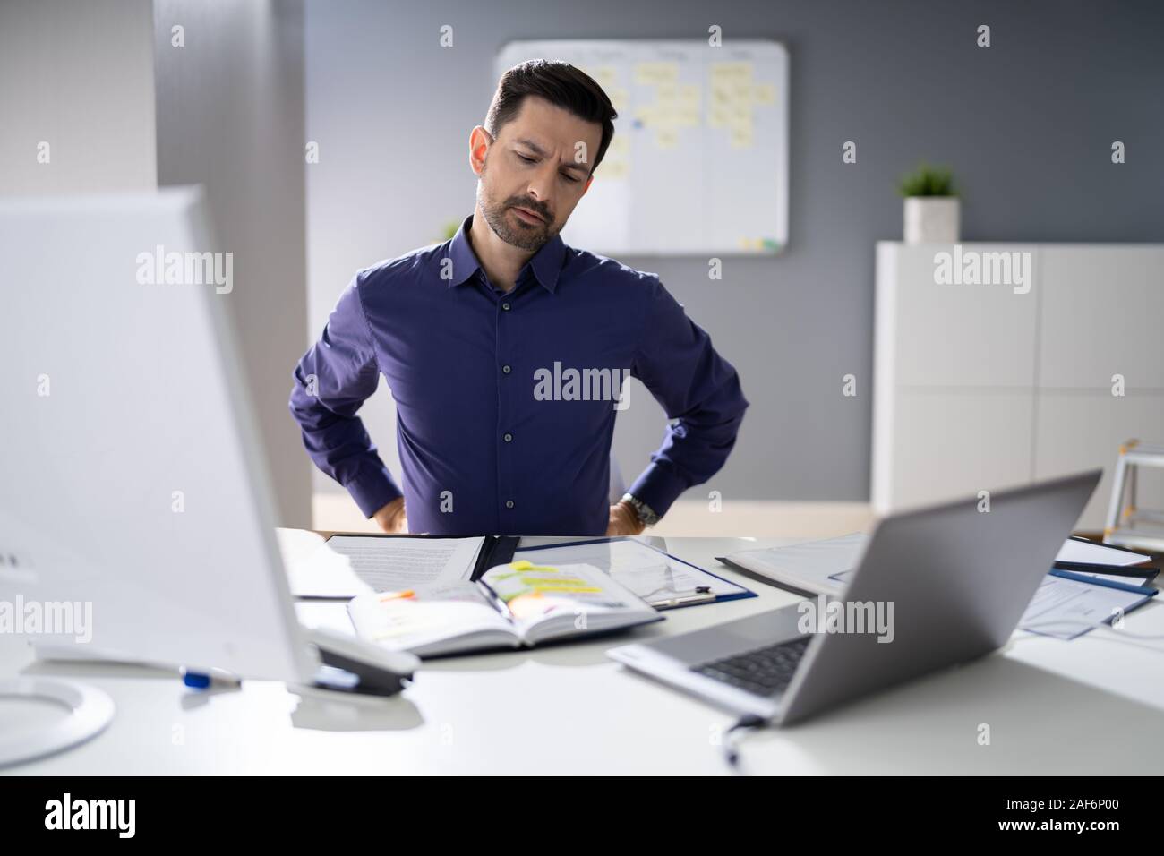 Businessman Having Back Pain While Sitting At Office Desk Stock Photo ...