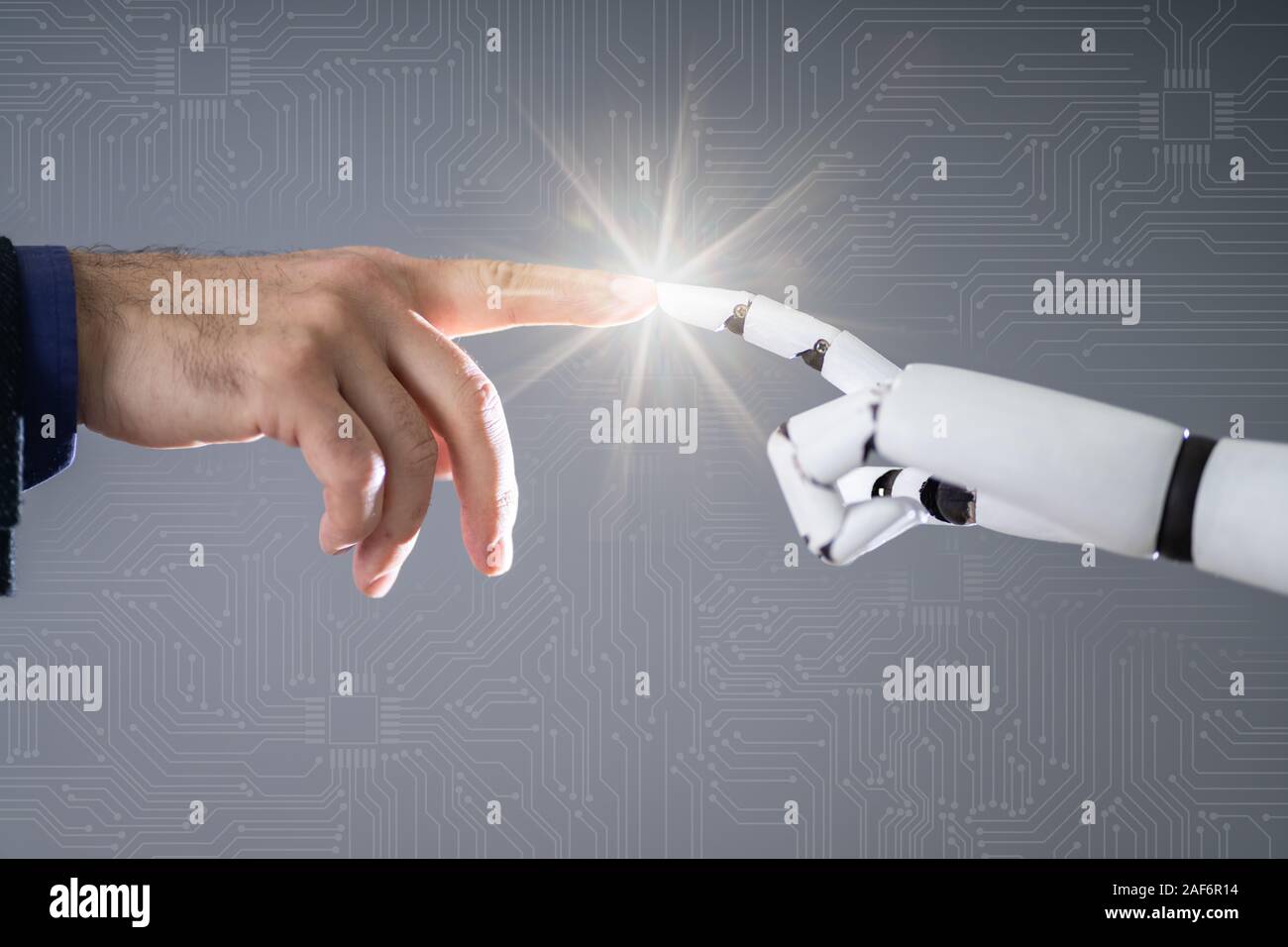 Robot Touching Human Finger Against Gray Background Stock Photo