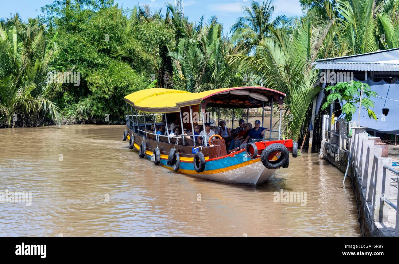 Tour boat with people Ben Tre Province Mekong Delta Vietnam Stock Photo