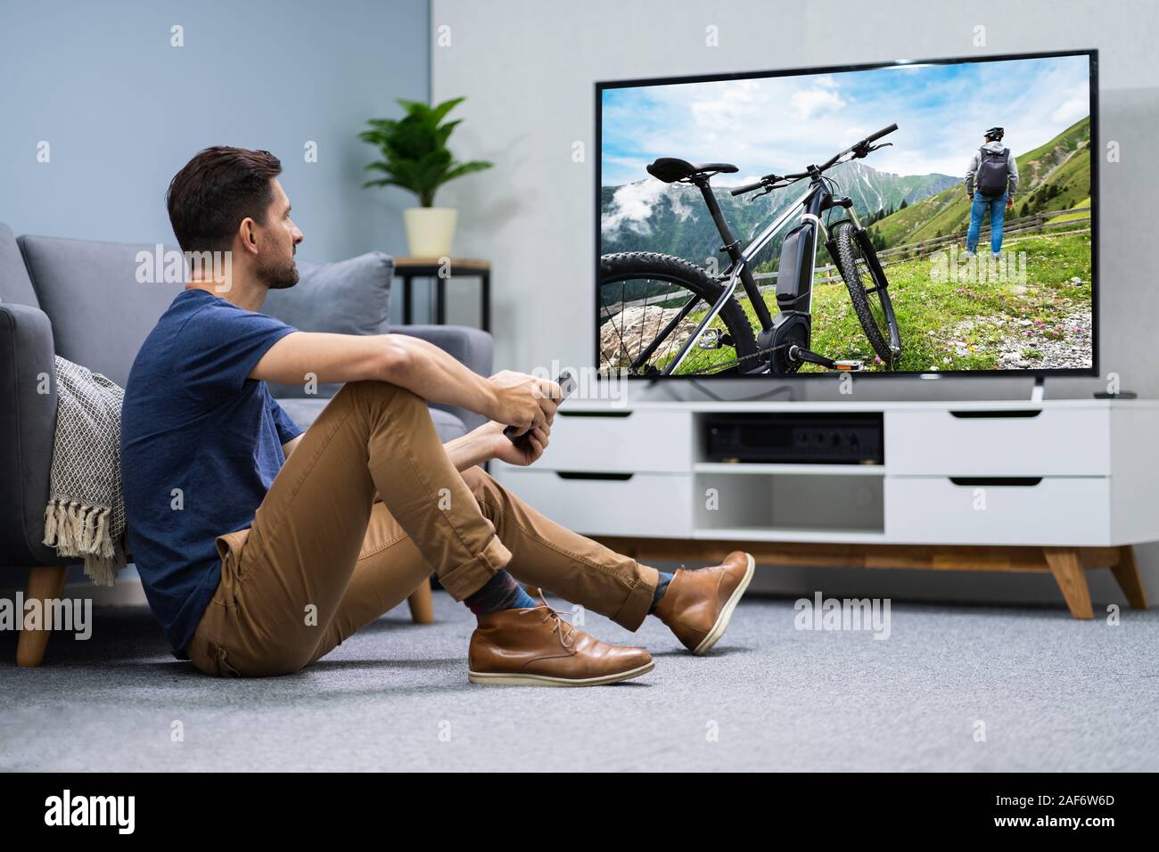 Man Streaming Television Channel Through Wireless Connection On Digital Tablet Stock Photo