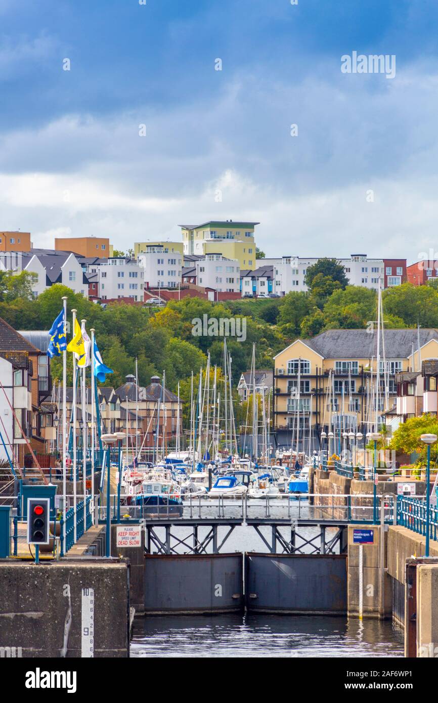 The entrance to Penarth Quays Marina in Cardiff Bay with attractive new housing architecture on the quayside and hillside beyond, Glamorgan, Wales, UK Stock Photo