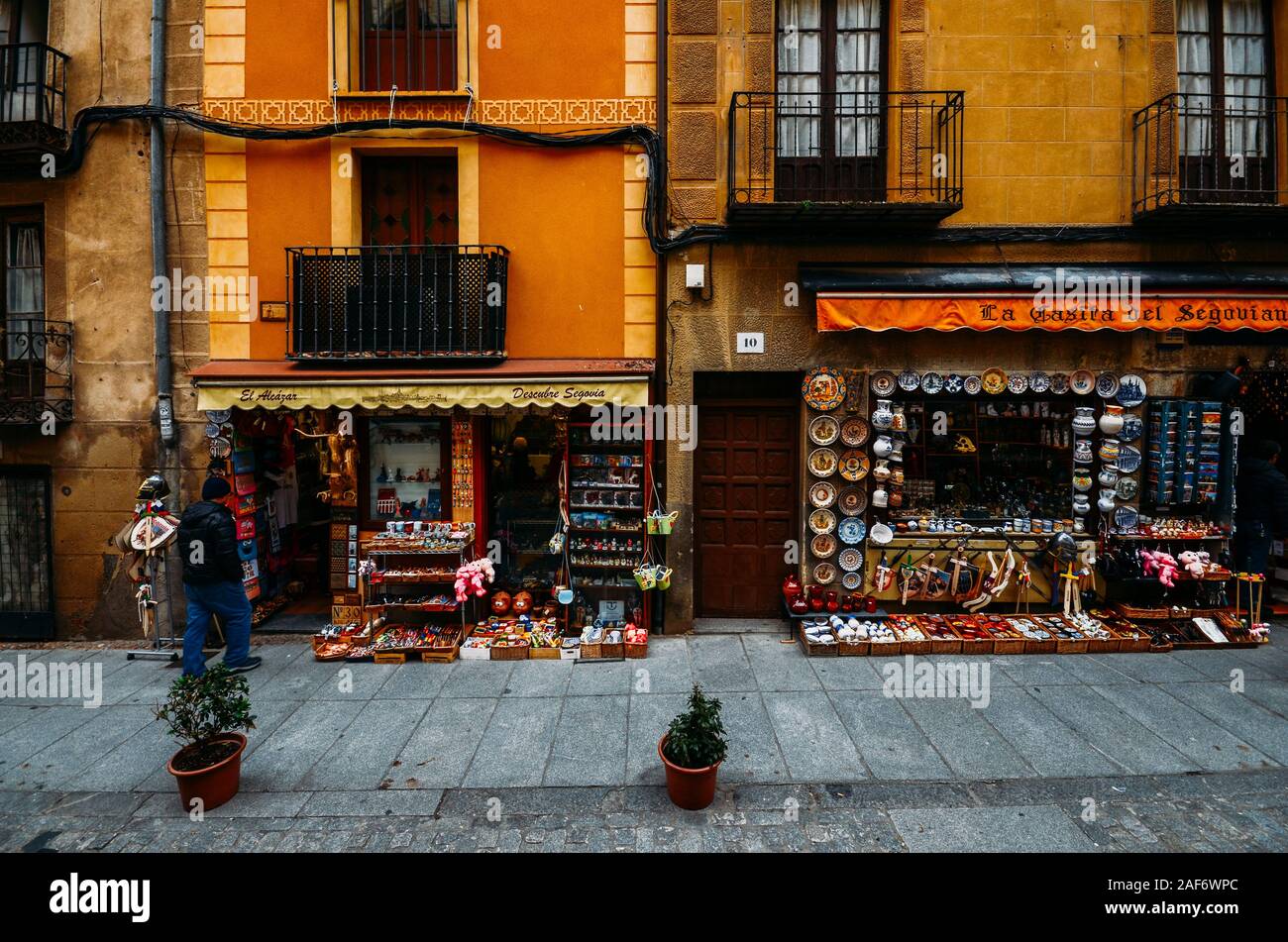 Segovia, Spain - Dec 8, 2019: Tourists walk along a street lined with souvenir shops in the historic centre of Segovia, Spain Stock Photo