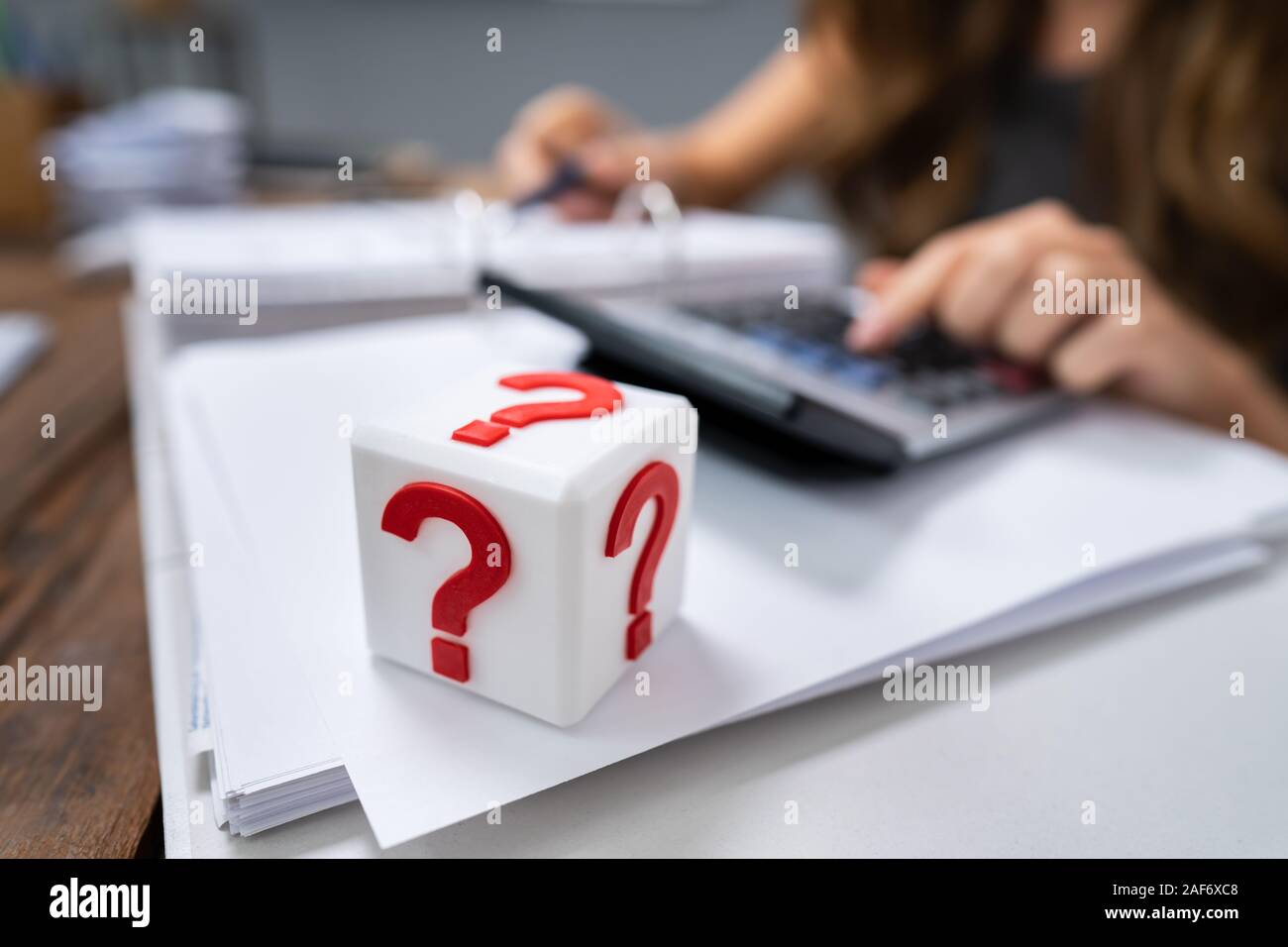 Cubic Block With Red Question Mark Sign On Desk Stock Photo
