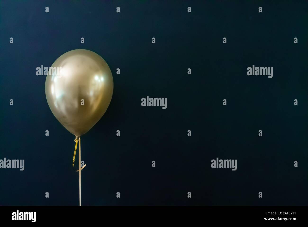 golden balloon on a dark background. Holiday Concept, Postcard Stock Photo