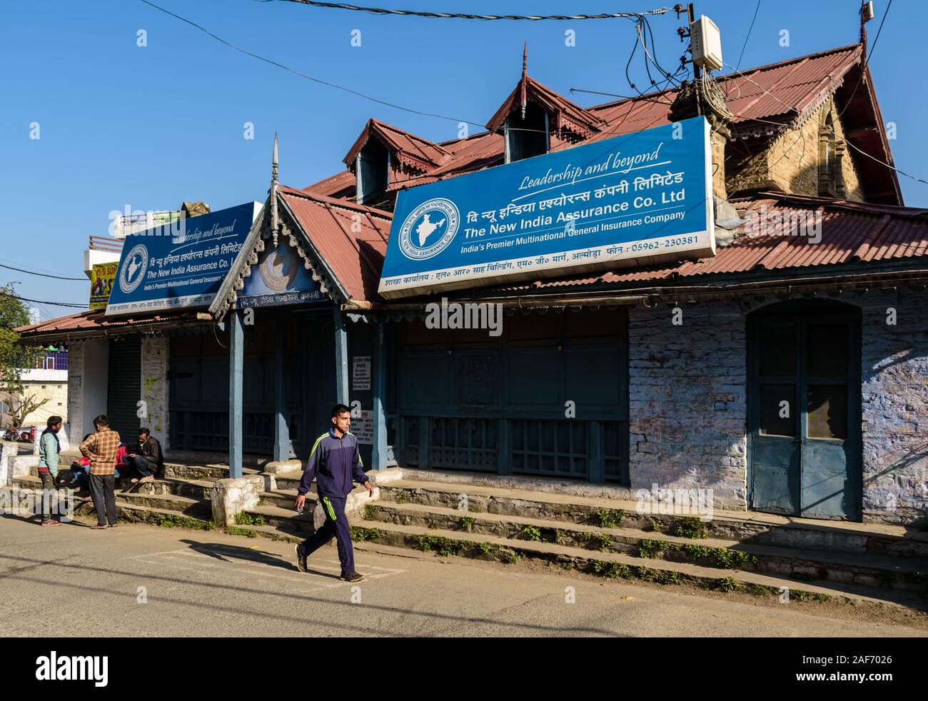 A quaint, old structure with stone walls, gables, wooden boards and slanting tin roofs that houses an Indian bank in Almora. Stock Photo