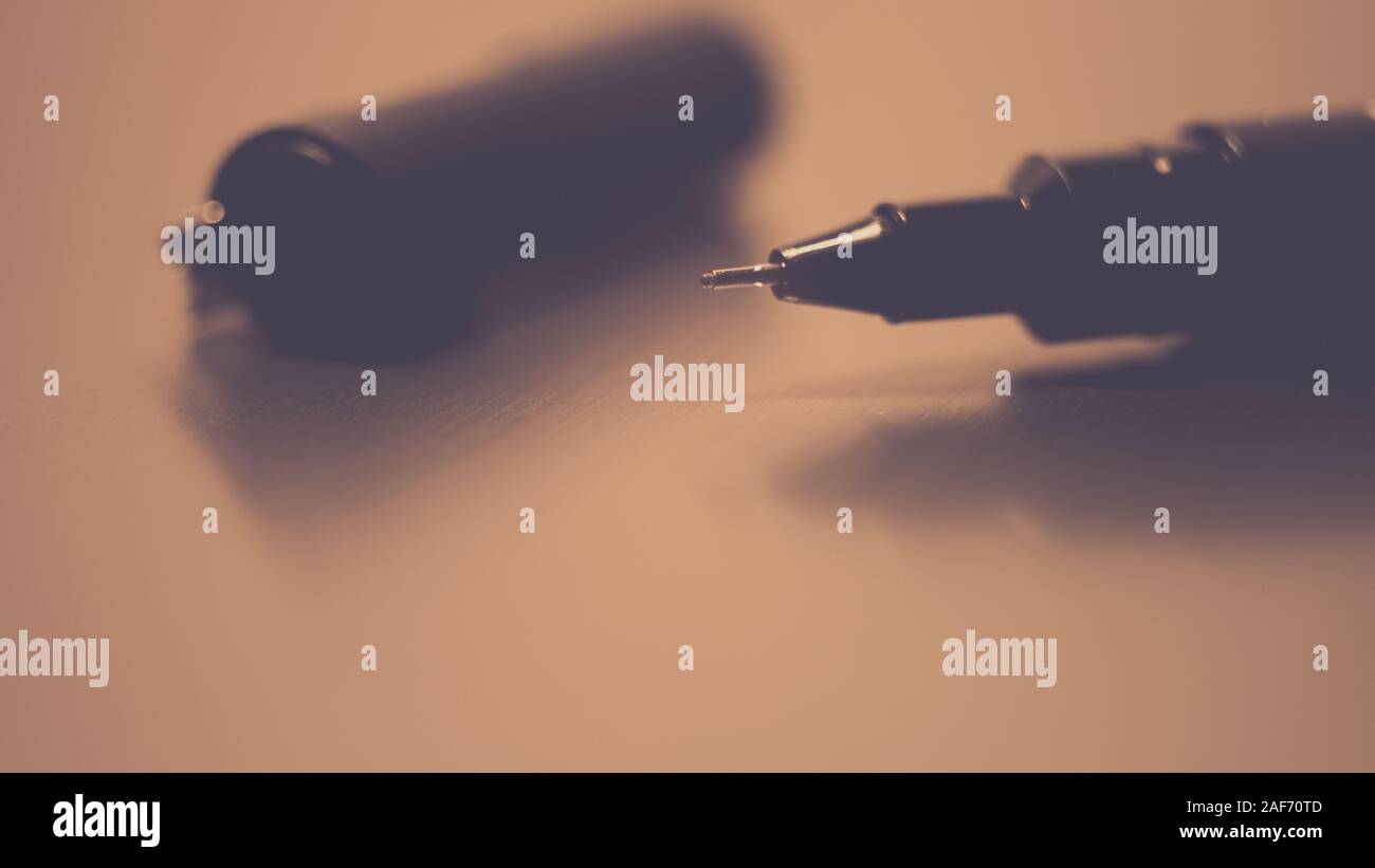 Black pen on a white notebook paper, accessory for creativity on the table Stock Photo