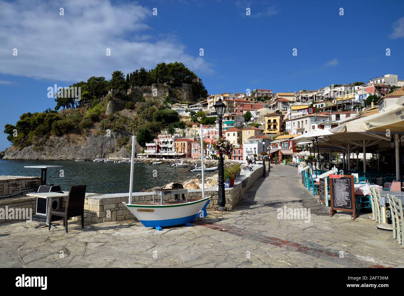 Parga, Greece - September 21, 2019: Colorful townscape with ruin of medieval castle and restaurants on promenade,  located on Ionian sea, a preferred Stock Photo