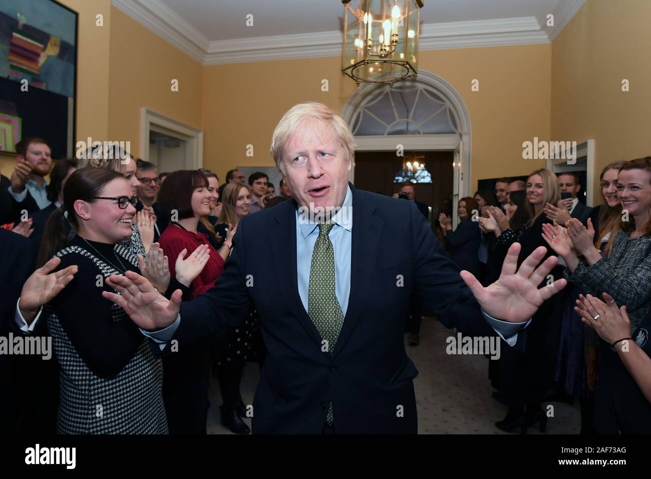 Prime Minister Boris Johnson is greeted by staff as he arrives back at 10 Downing Street, London, after meeting Queen Elizabeth II and accepting her invitation to form a new government after the Conservative Party was returned to power in the General Election with an increased majority. Stock Photo
