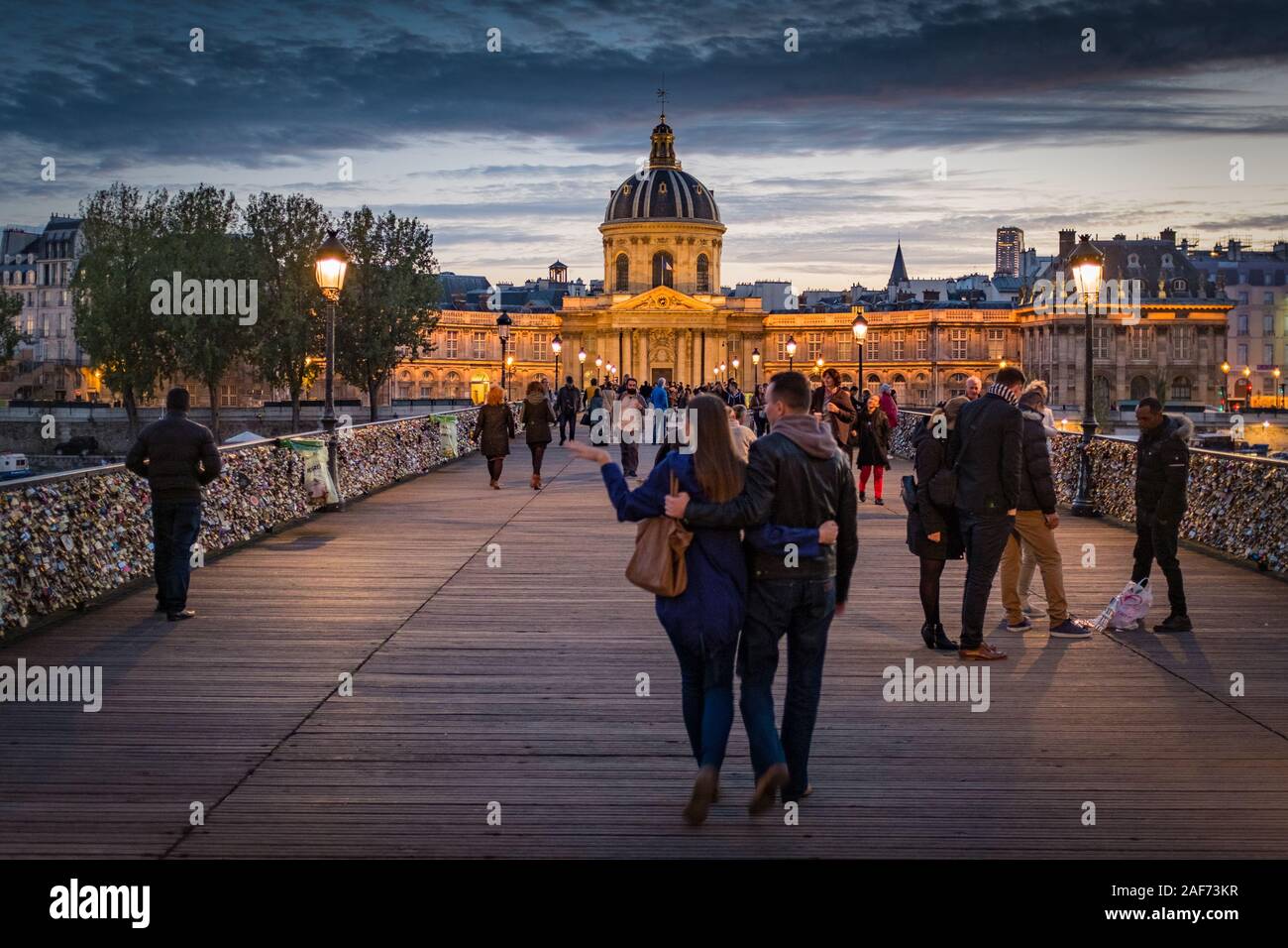 Romantic evening at Pont des Arts, Paris, France. In the background you see 'Institut de France' Stock Photo