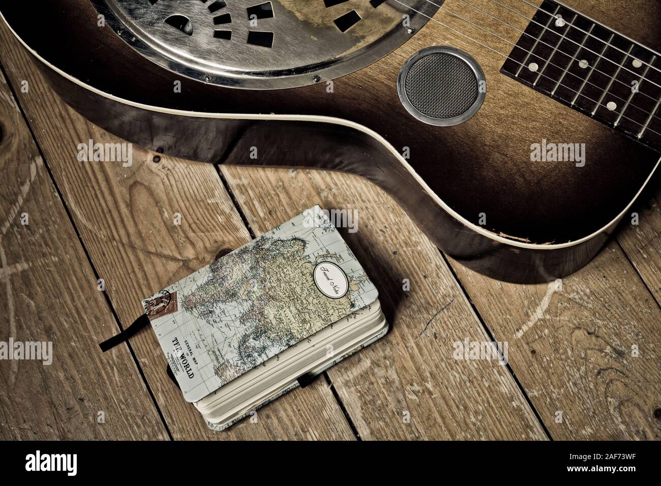A Diary and a detail of a  Dobro guitar on a wooden background Stock Photo