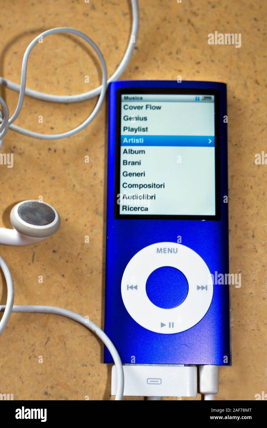 Milan, Italy - June 4, 2019. Apple iPod Nano 8Gb, blue Music Player isolated on wood background with Apple earbuds and charger cable attached. The dev Stock Photo