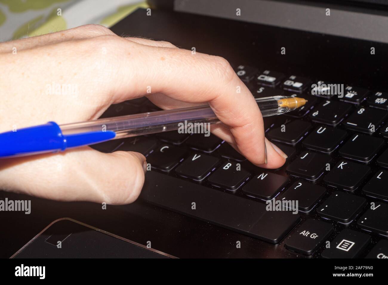 Woman with a pen in the hand typing on the computer Stock Photo