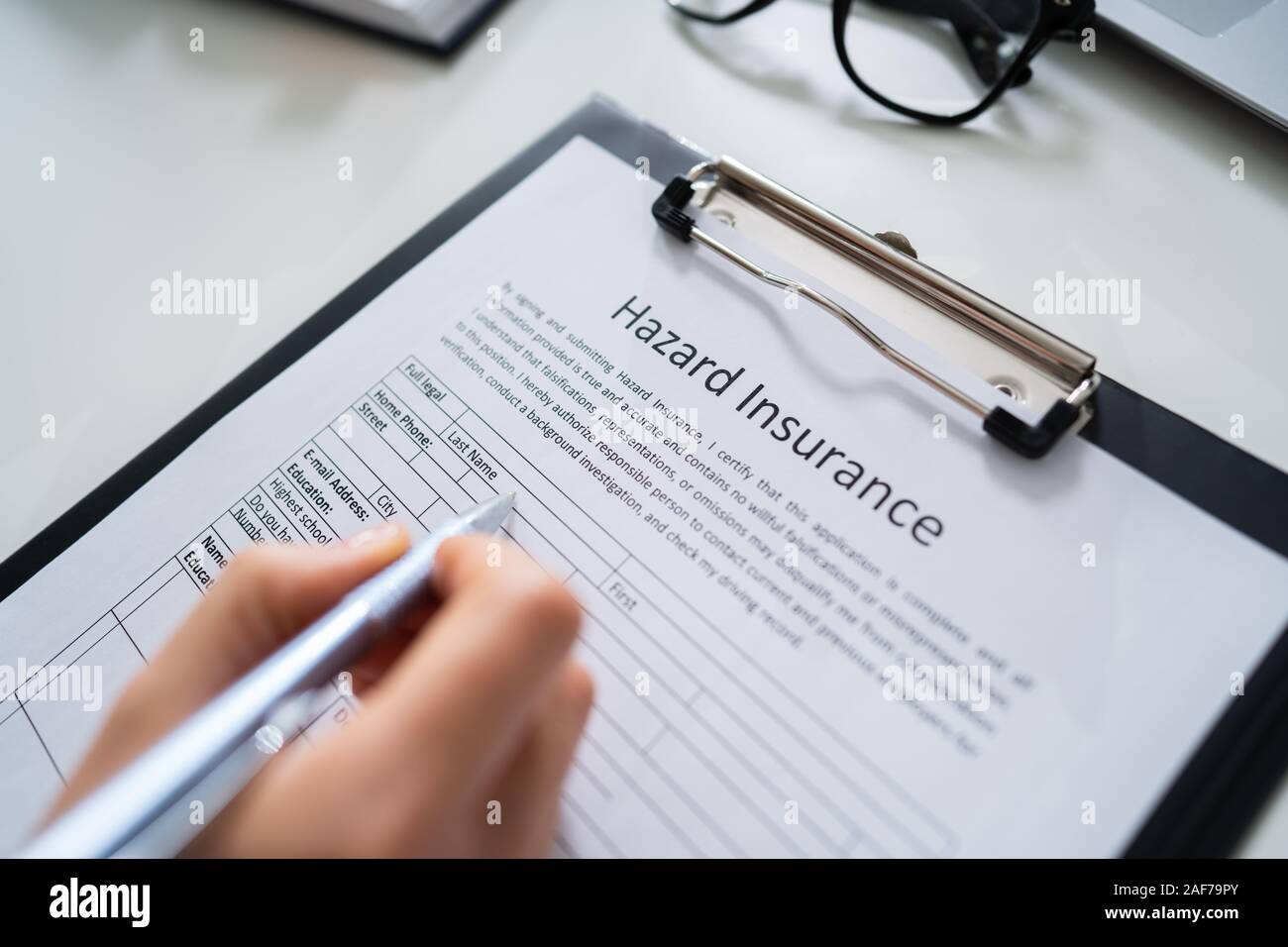 Person Filling Hazard Insurance Form At Desk Stock Photo Alamy
