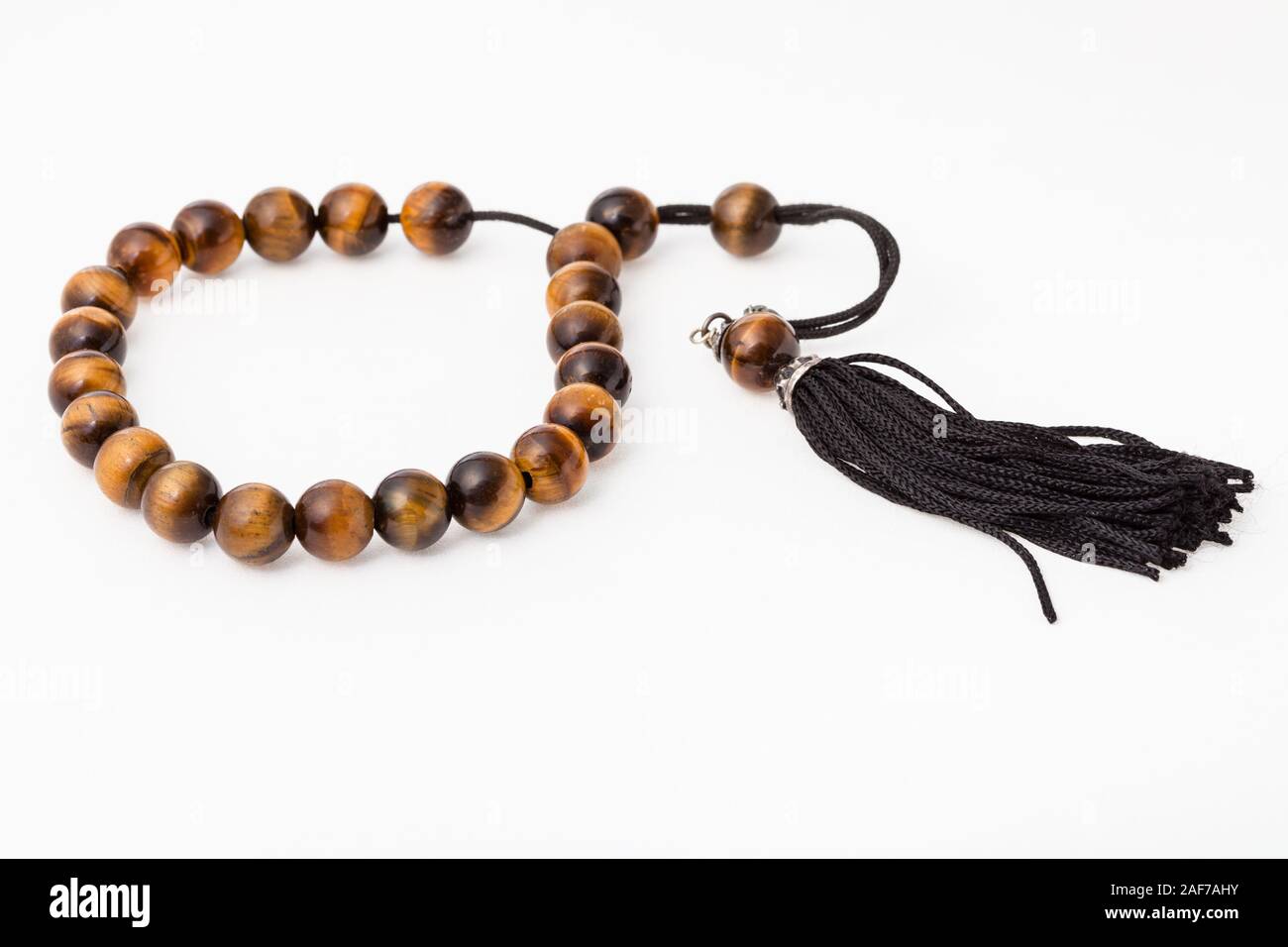 worry beads from tiger's eye gemstones on white paper background Stock Photo