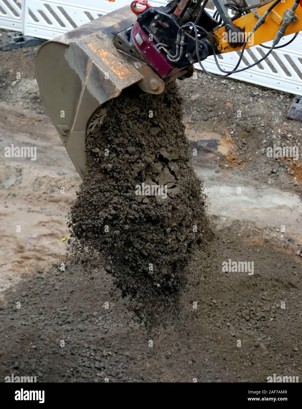 a shovel excavator unloads a load of dirt on a road construction site Stock Photo