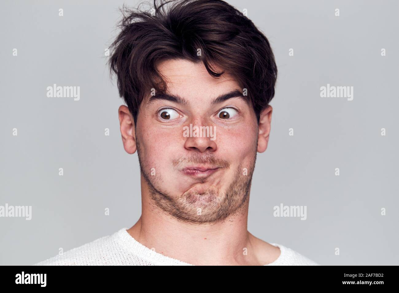 Head And Shoulders Studio Shot Of Man Pulling Faces And Smiling At Camera Stock Photo