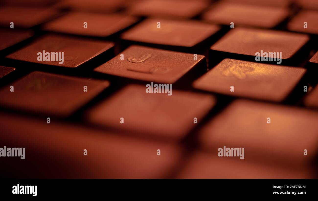 Black keyboard lit by red light, macro photo. Stock Photo