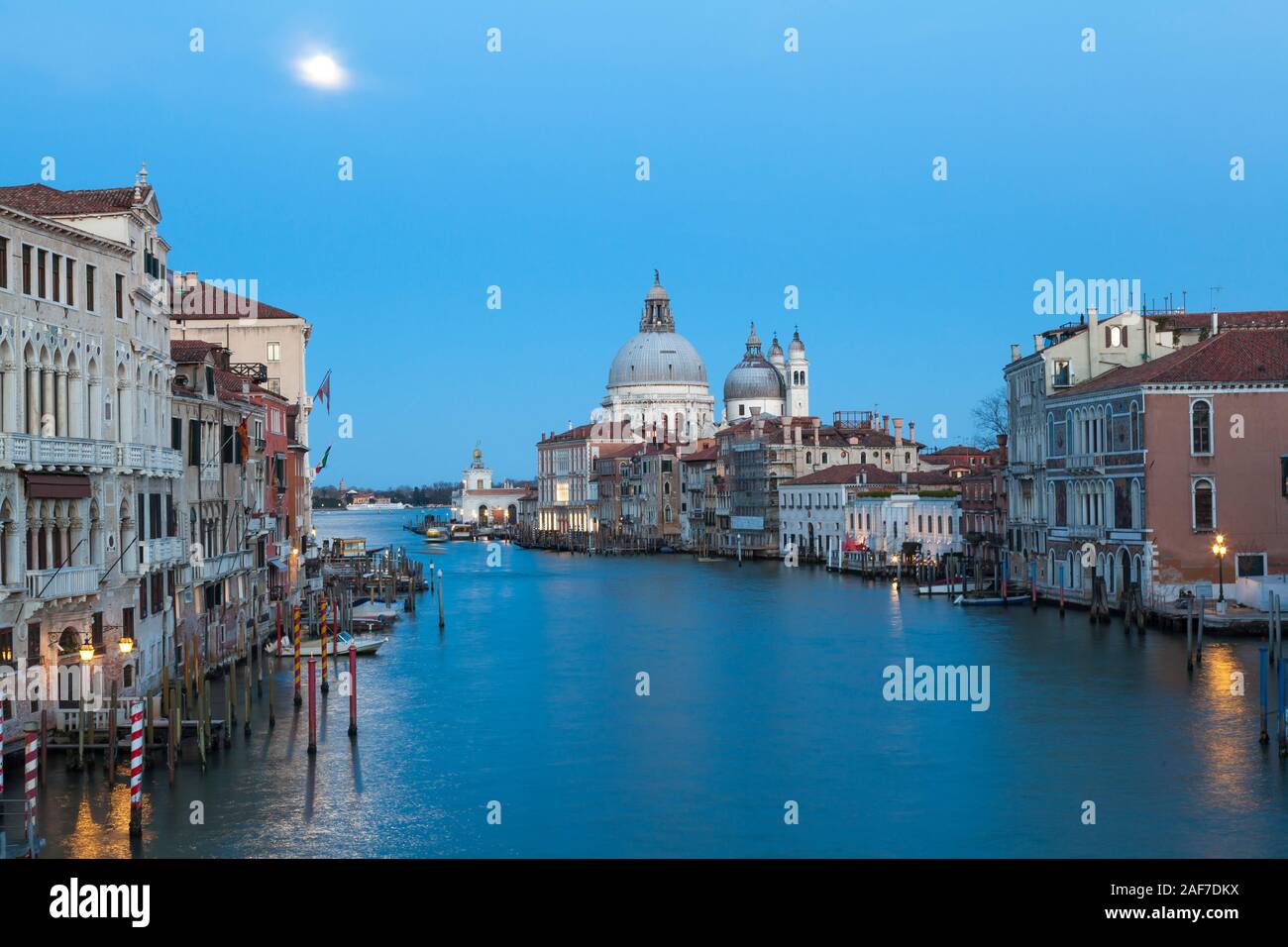 Full moon over the Grand Canal, Venice, Veneto, Italy at twilightwith reflection on the water and view to Basilica Santa Maria della Salute Stock Photo