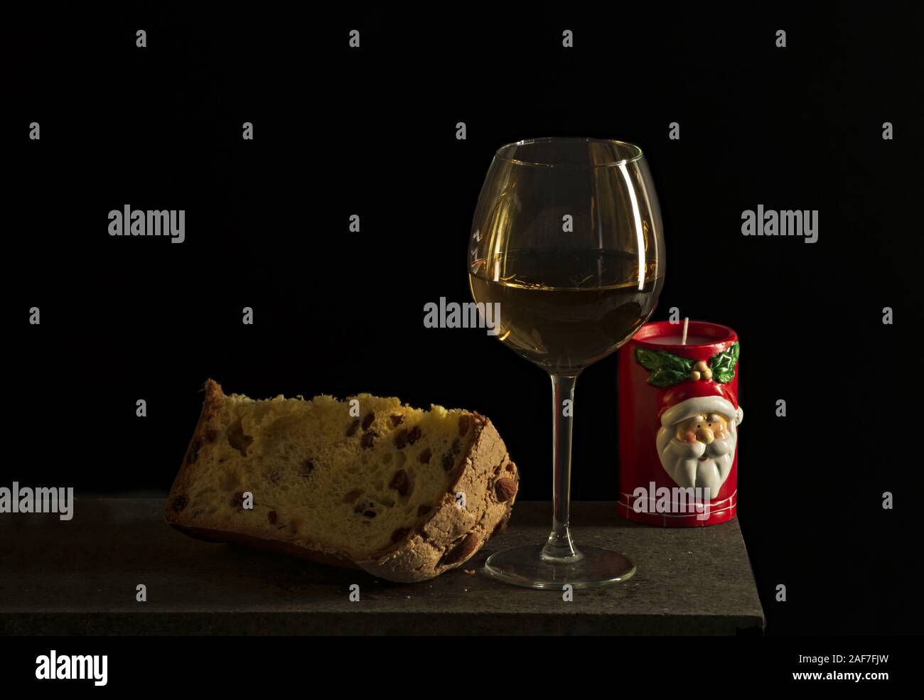 panettone dolce di natale italiano con bicchiere di vino bianco e candela  fetta Stock Photo - Alamy