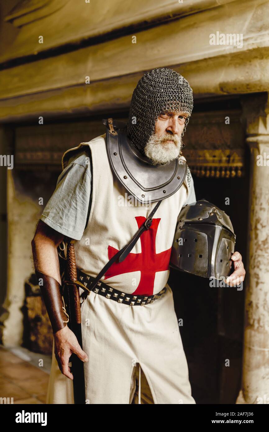 Authentic knight in medieval crusader outfit with helmet, chainmail and sword Stock Photo