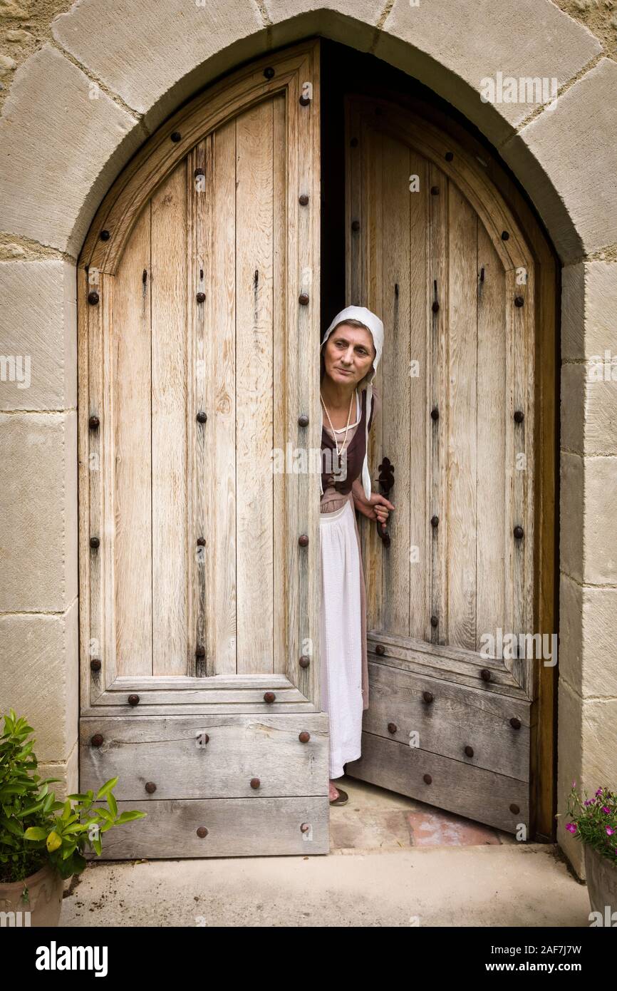 Woman in medieval wench outfit standing in the door of a French medieval castle Stock Photo