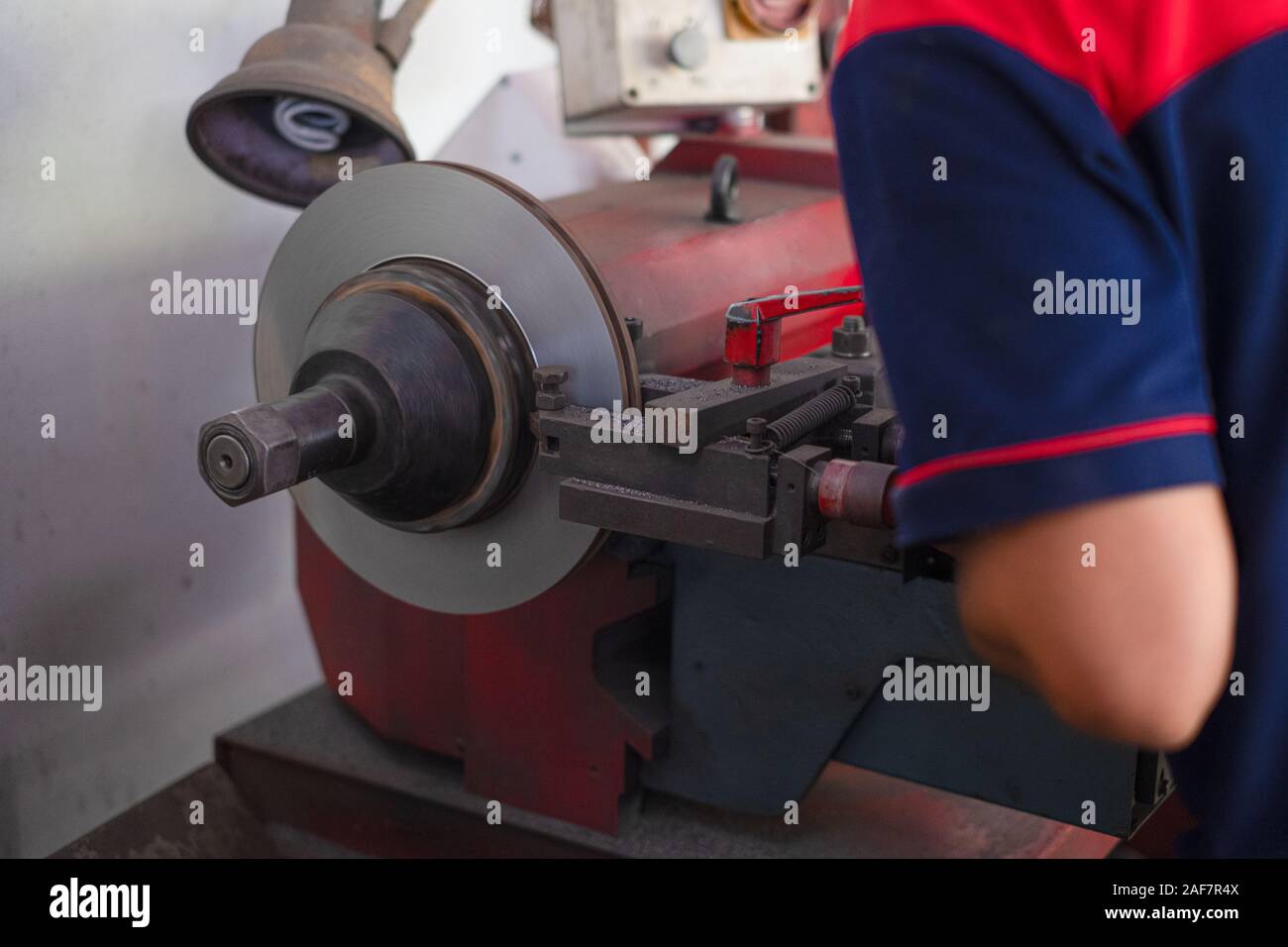 Mechanic man repairing brake use lathe tool polishing disc brakes of