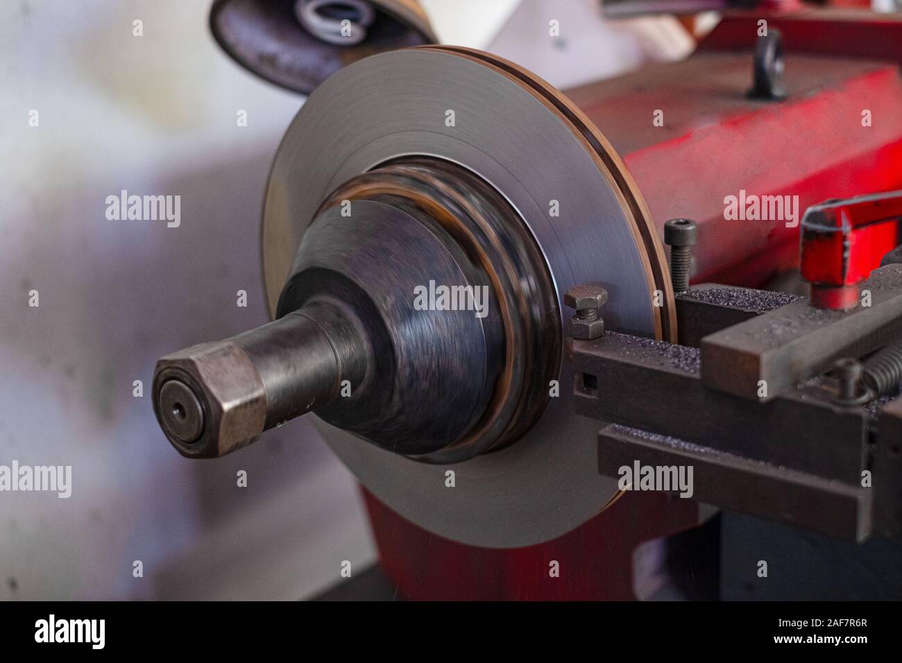 Mechanic man repairing brake use lathe tool polishing disc brakes of