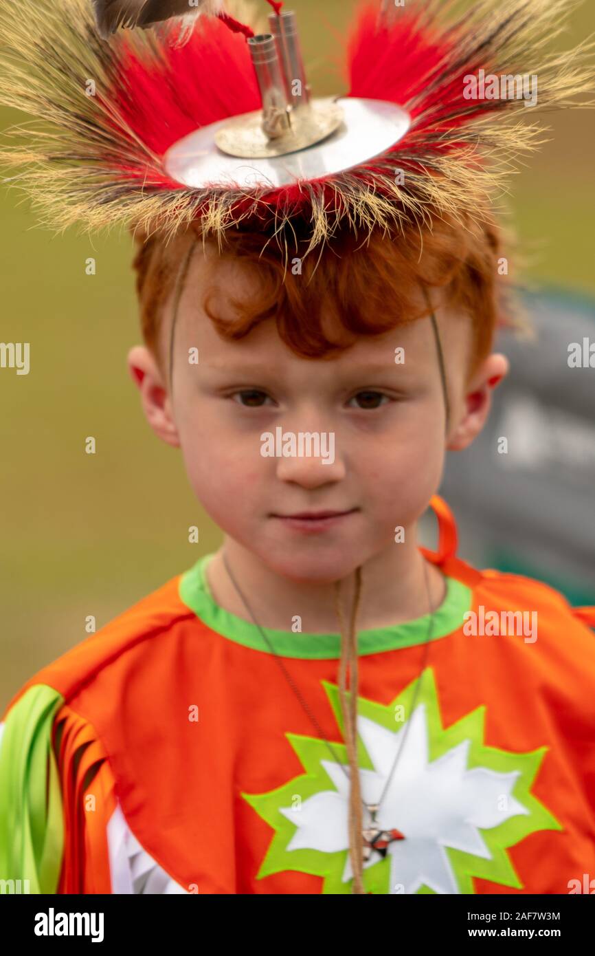 A young, red-haired boy wearing a headdress at the Poarch Creek Indian Thanksgiving Pow Wow Stock Photo