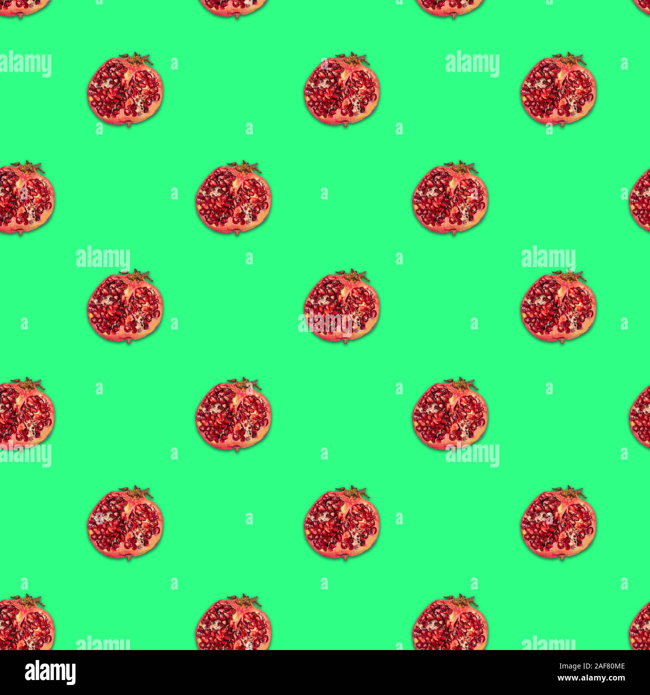 Pomegranate half seamless pattern on green background, texture Stock Photo