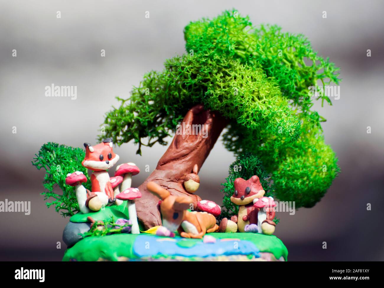 Arts and crafts: plasticine creative set representing animals in the forest: a fox and a squirrel looking at a deer drinking water from a pond. Stock Photo