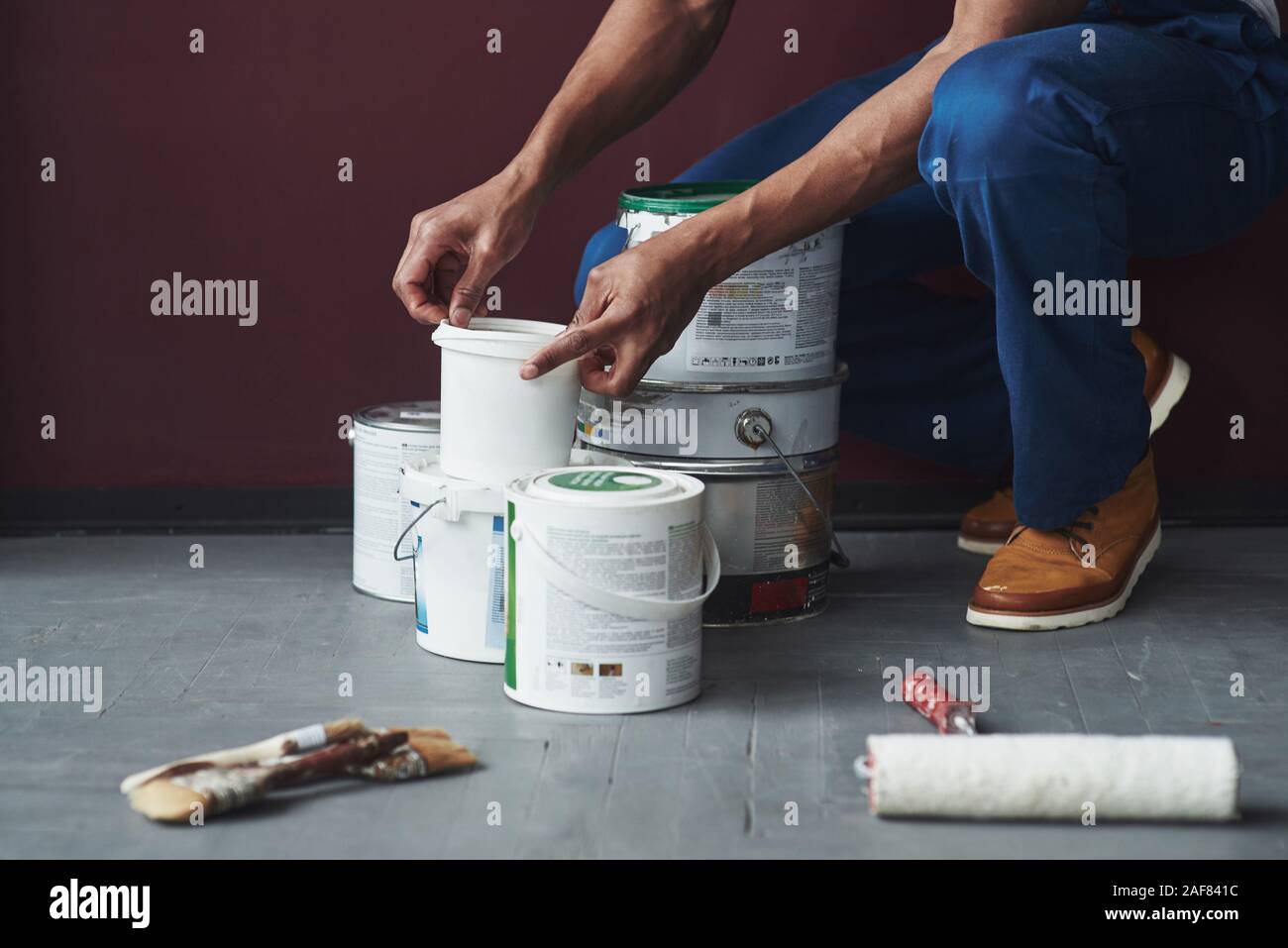 Preparing process. Young african american worker in the blue uniform have some job Stock Photo