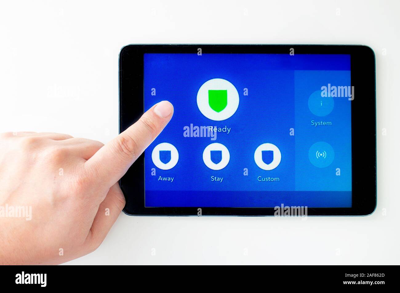 Digital Touch Screen Home Alarm Panel to control security system with a person's hand/finger Stock Photo