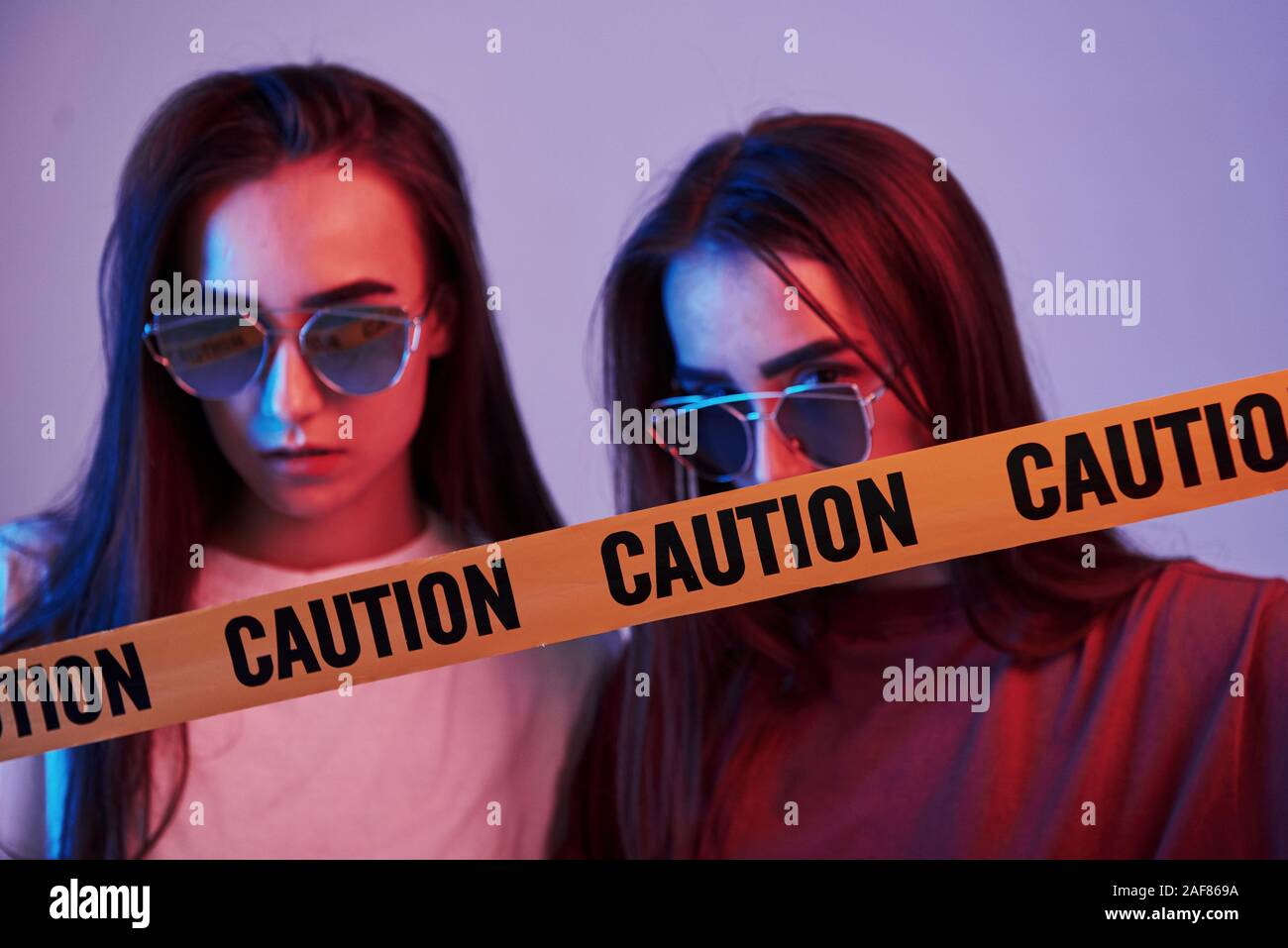 Danger, caution, yellow tape. Studio shot indoors with neon light