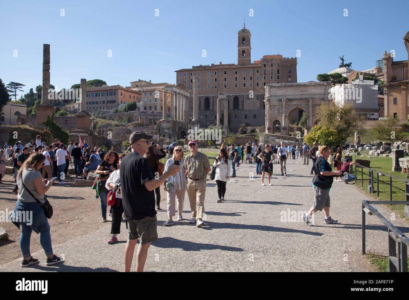 Masses of tourists at the Roman Forum is a forum (plaza) surrounded by the ruins of several government buildings Stock Photo