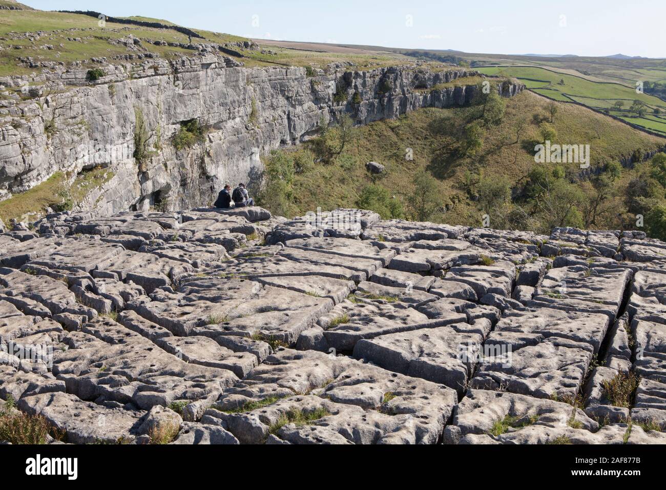People picnic on the limestone pavement above Malham Cove in Yorkshire