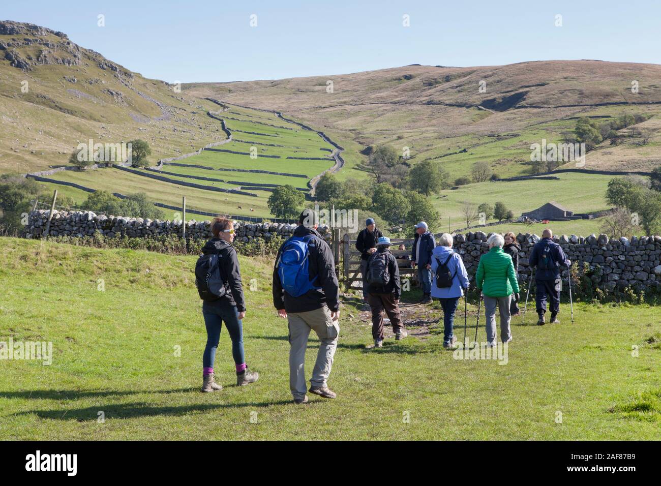 A group of walkers on the circular footpath around Malham Cove and Gordale Scar in the Yorkshire Dales National Park Stock Photo