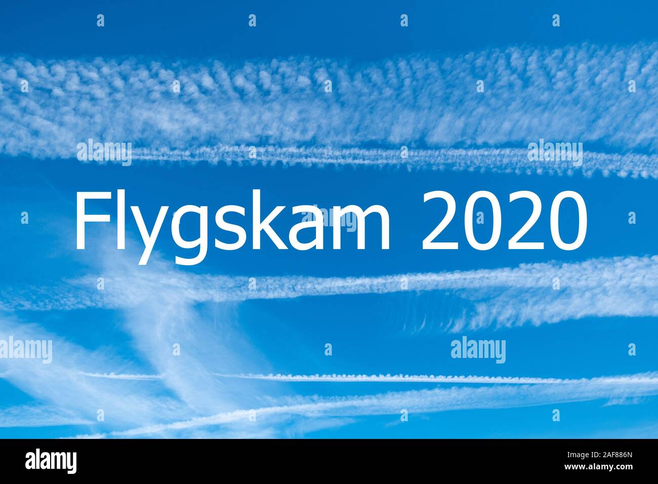 Climate change and flygskam concept image with blue sky and vapour trails from aircraft with the words Flygskam 2020 Stock Photo