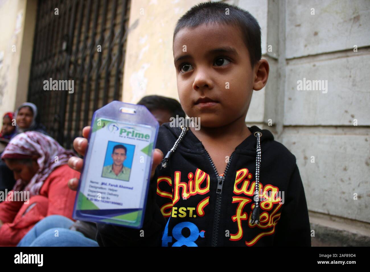 Dhaka, Bangladesh. 13th Dec, 2019. A three years old kid, Atique shows his Father's ID card at the Morgue of Dhaka Medical College Hospital in Dhaka.At least 13 people were killed and nearly 20 people were critically injured when a fire swept through an illegal plastics factory outside the Bangladeshi capital Dhaka. Credit: SOPA Images Limited/Alamy Live News Stock Photo