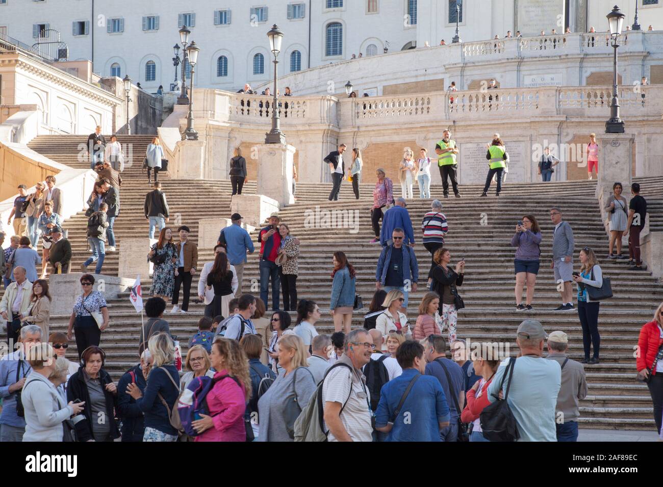 Security guards on the Spanish Steps in Rome stop tourists sitting down to avoid congestion around a popular attraction Stock Photo