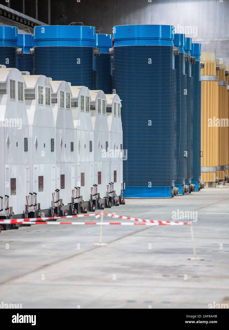 11 December 2019, Lower Saxony, Gorleben: Containers with high-level radioactive waste and transport hoods are in interim storage. The Gorleben nuclear waste storage facility is an interim storage facility for spent fuel elements and high-level radioactive waste. To date, 13 Castor transports with highly radioactive material have reached the transport container warehouse between 1995 and 2011. Until a repository has been found, the nuclear waste is to be temporarily stored there. Photo: Lucas Bäuml/dpa Stock Photo