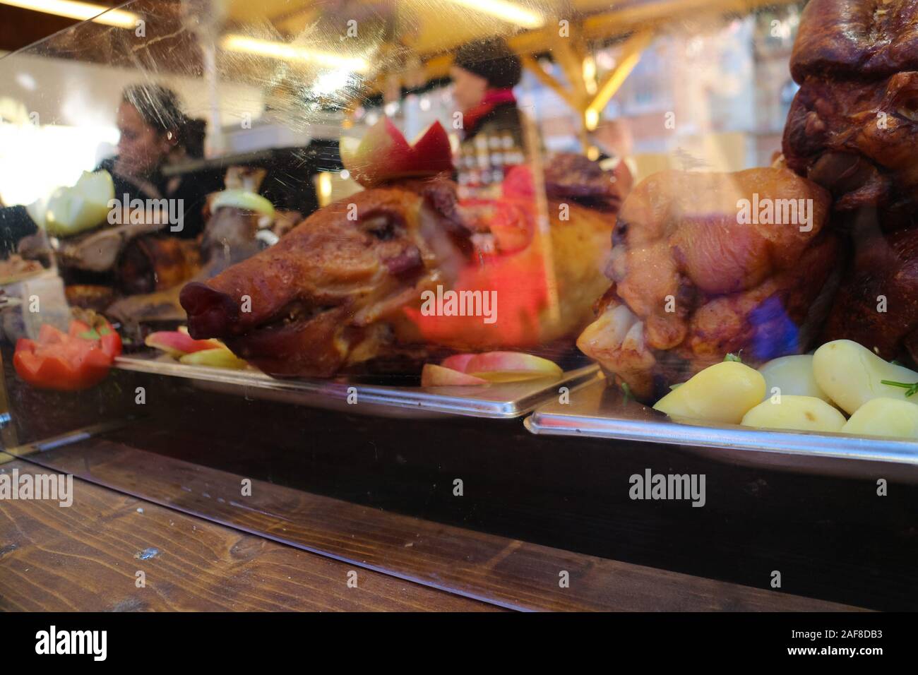 Budapest, Hungary - December 8, 2019: pig head of a roasted pork with apples on display at a market stall on one of Budapest's christmas markets. Stock Photo