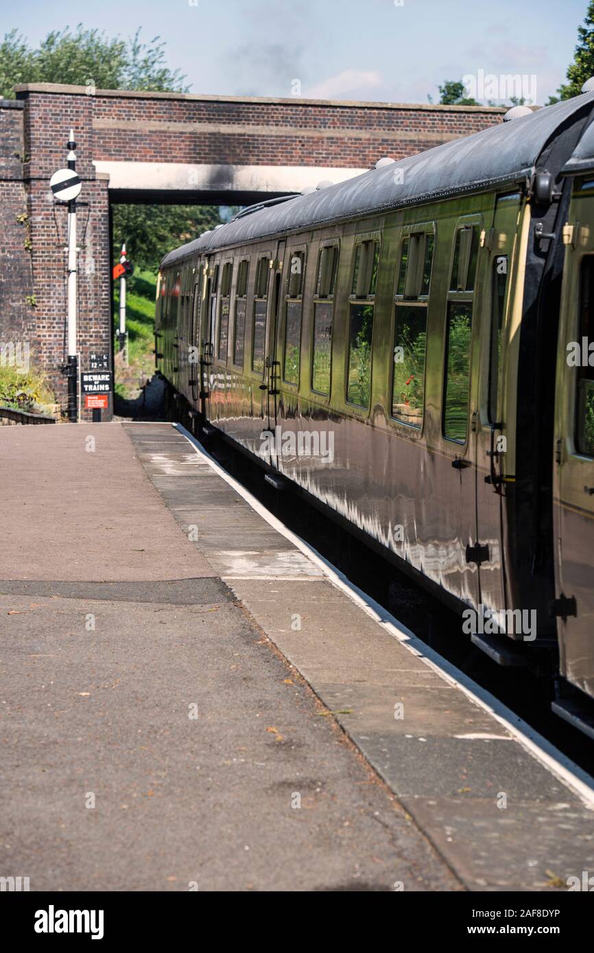 Steam train pulling away from the heritage railway station at Winchcombe in Gloucestershire, England, UK Stock Photo