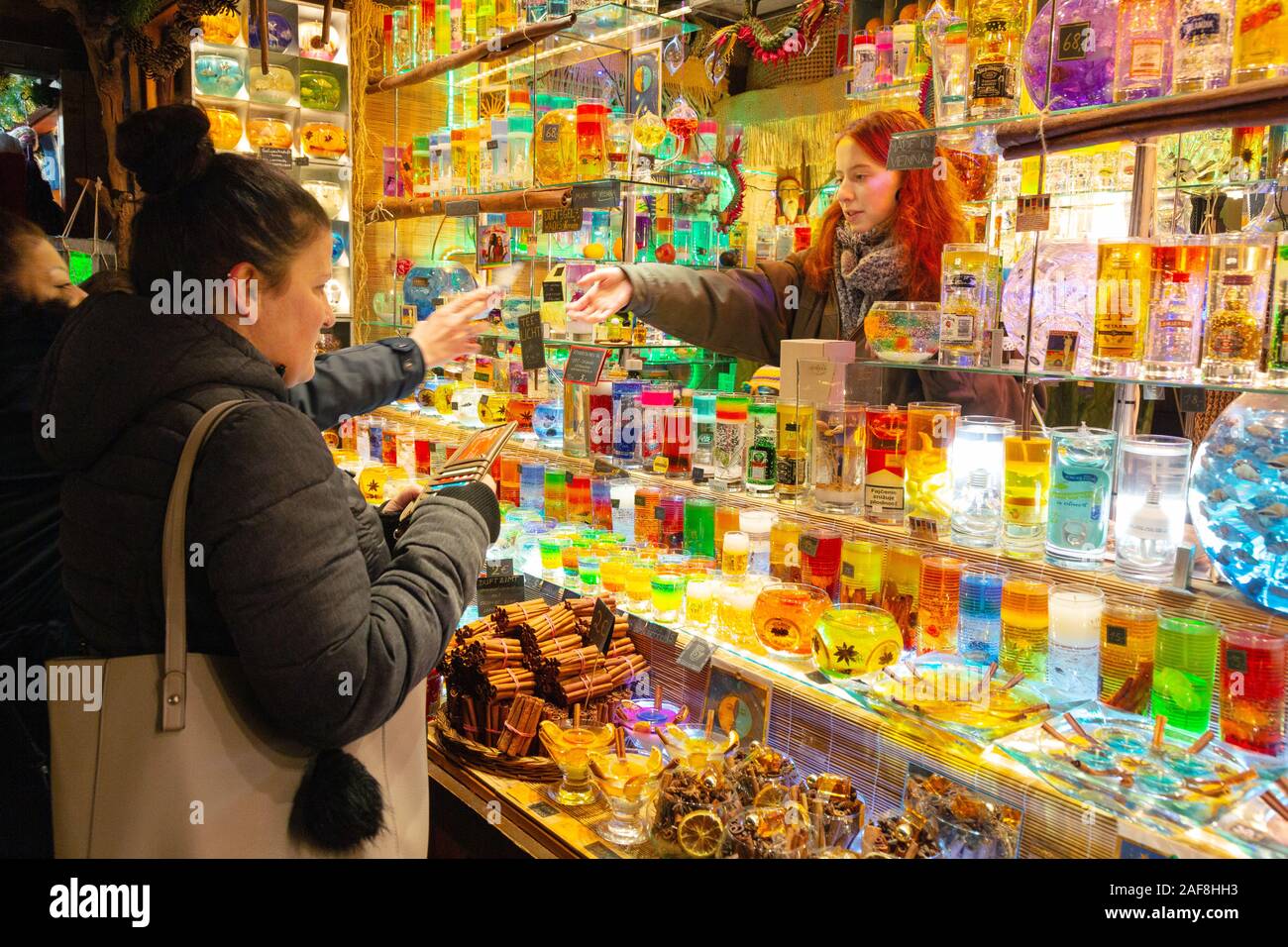 Vienna christmas markets - customers buying candles in a colourful Christmas candle stall; Rathaus Christmas Market, Rathausplatz, Vienna Austria Stock Photo