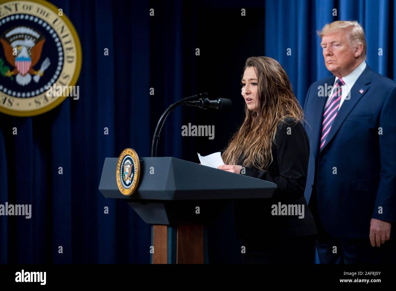 Washington DC, USA. 12 December, 2019. U.S President Donald Trump listens as Brittany Hasemann of Colorado, delivers remarks at the White House Summit on Child Care and Paid Leave: Supporting America’s Working Families on in the South Court Auditorium of the Eisenhower Executive Office Building at the White House December 12, 2019 in Washington, DC. Credit: Tia Dufour/White House Photo/Alamy Live News Stock Photo