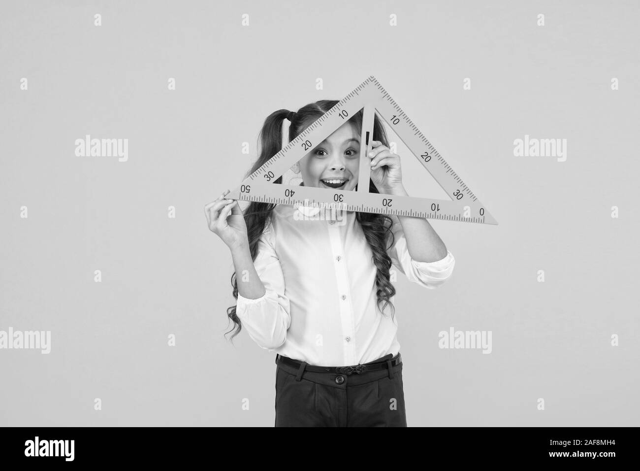 Knowledge day. Schoolgirl school uniform hold big ruler geometry school ...