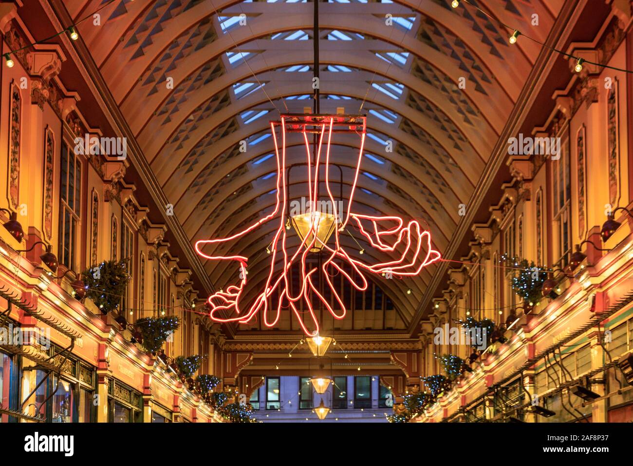 Leadenhall Market at Christmas, with 'The Source' by Patrick Tuttofuoco, neon hands communicating via sign language, Sculpture in the City, London, UK Stock Photo