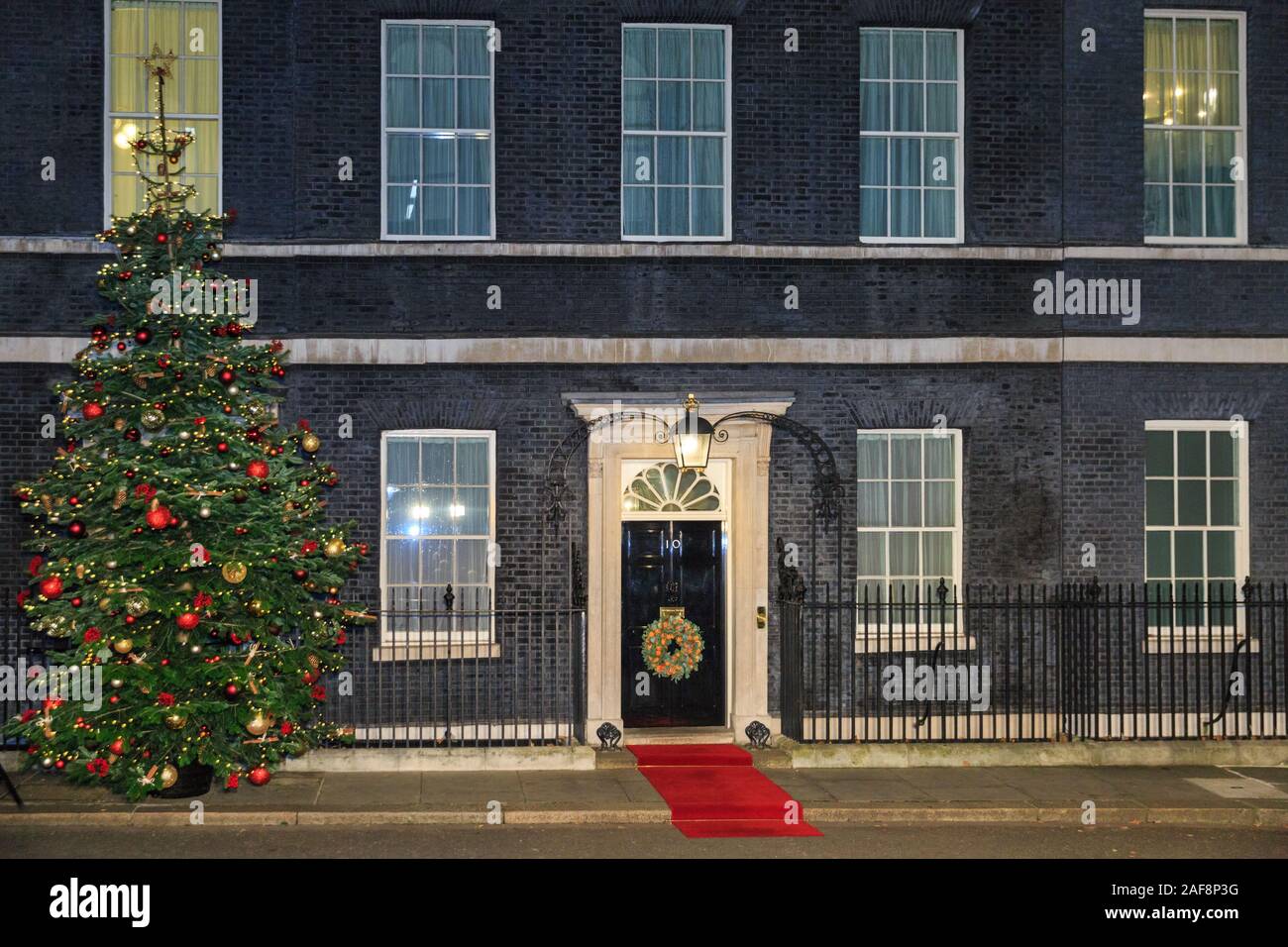 Downing Street decorated Christmas Tree, door wreath and red carpet exterior, London, Westminster, UK Stock Photo